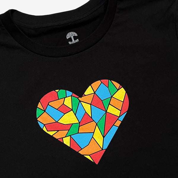 Close up on full-color Roots logo mosaic colors in a heart on the chest of a black t-shirt.