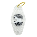 The backside of a translucent plastic motel keychain with an Oakland aerial view map with Lake Merrit in the center.