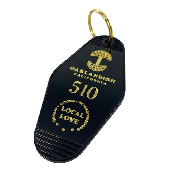 Black motel-style keychain with gold Oaklandish Logo and wordmark and 510 local love logo.