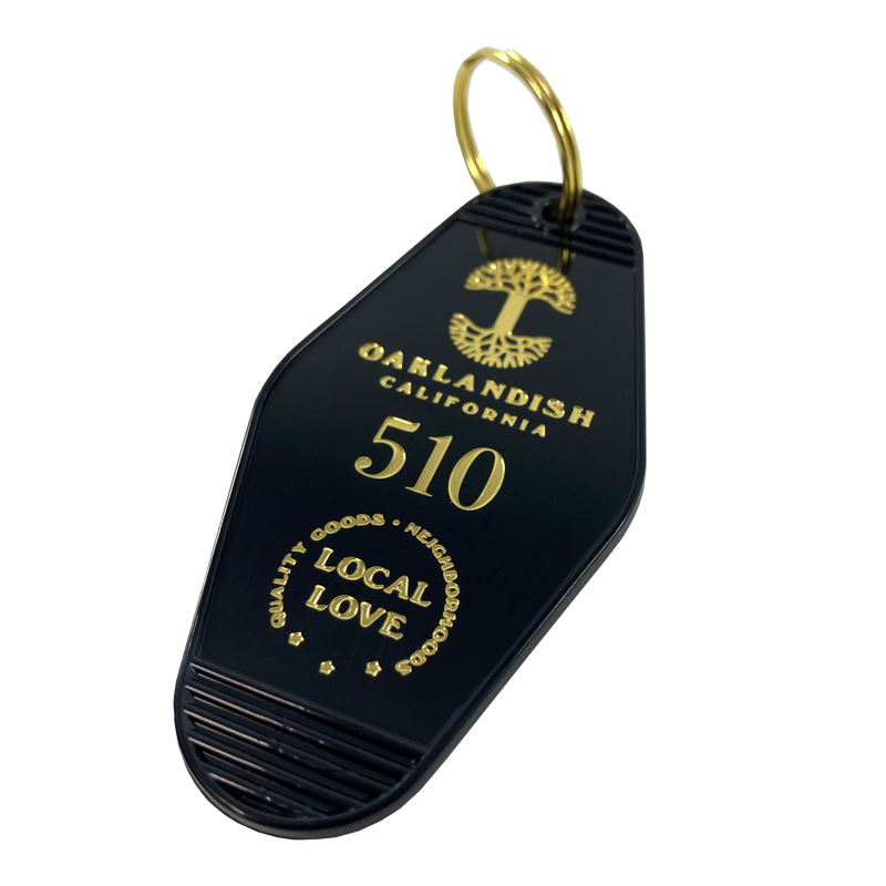Black motel-style keychain with gold Oaklandish Logo and wordmark and 510 local love logo.