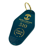 Detailed angle image of blue vintage motel-style keychain with gold Oaklandish Logo and wordmark and 510 local love logo.