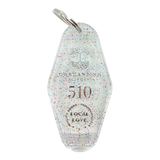 Translucent white with rainbow glitter motel-style keychain with Oaklandish Logo and 510 local love.