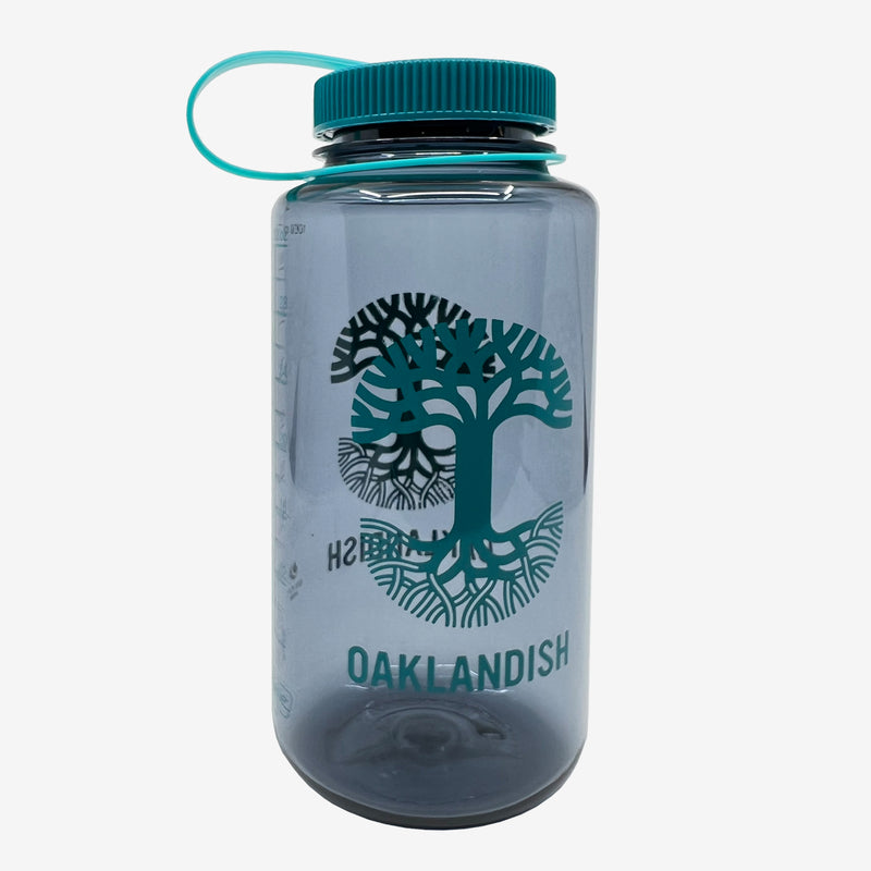 Transparent smoke grey Nalgene water bottle with Oaklandish tree logo and wordmark on both sides and wide mouth screw top lid.