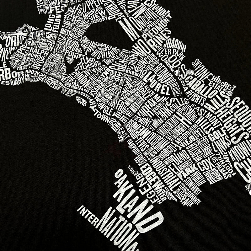 Close up of Oakland neighborhood map  with Oakland Nation wordmark on black t-shirt.