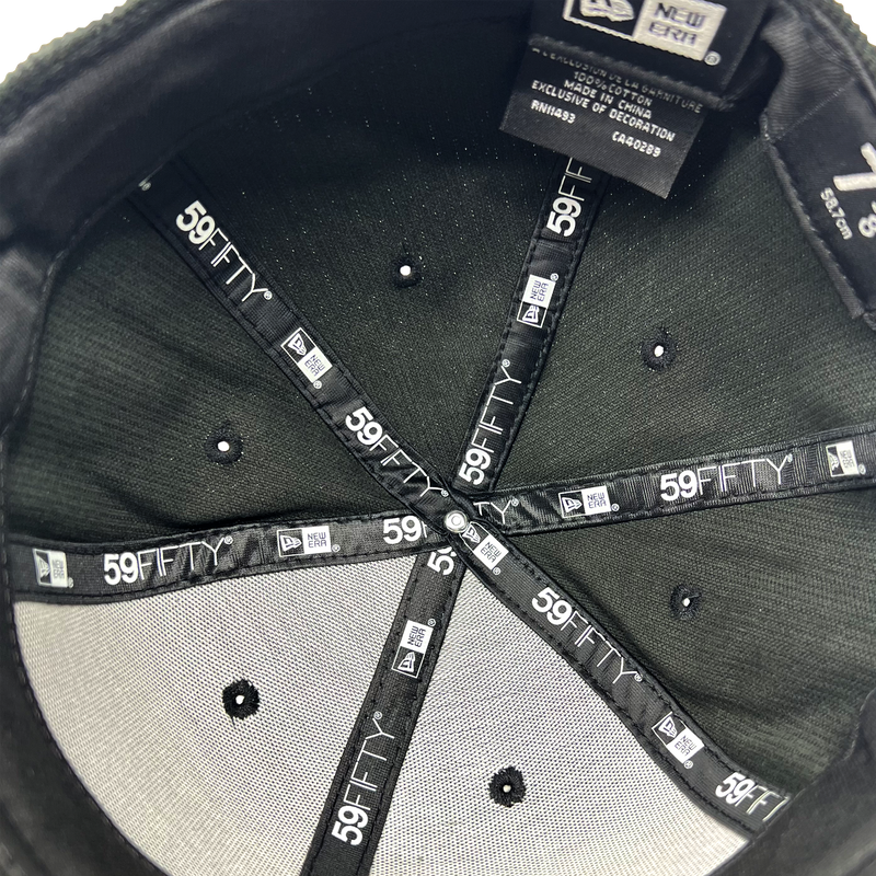 Inside the crown of New Era 59FIFTY fitted black cap with black taping with New Era wordmark on repeat.