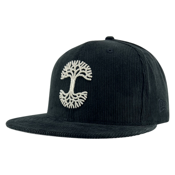 New Era black corduroy fitted cap with silver embroidered Oaklandish tree logo - angled to show New Era logo on left wear side.