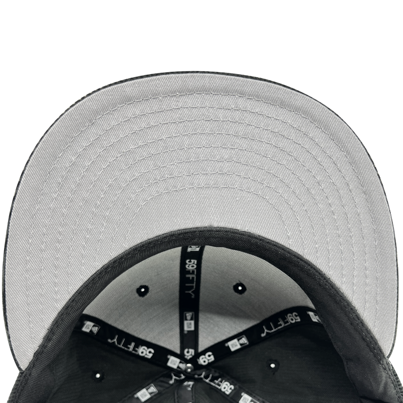 Inside the crown of New Era 59FIFTY fitted black cap with black taping with New Era wordmark on repeat and grey under visor.