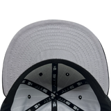 Inside the crown of New Era 9FIFTY fitted black pinstripe cap with black taping with New Era wordmark on repeat and grey under visor.