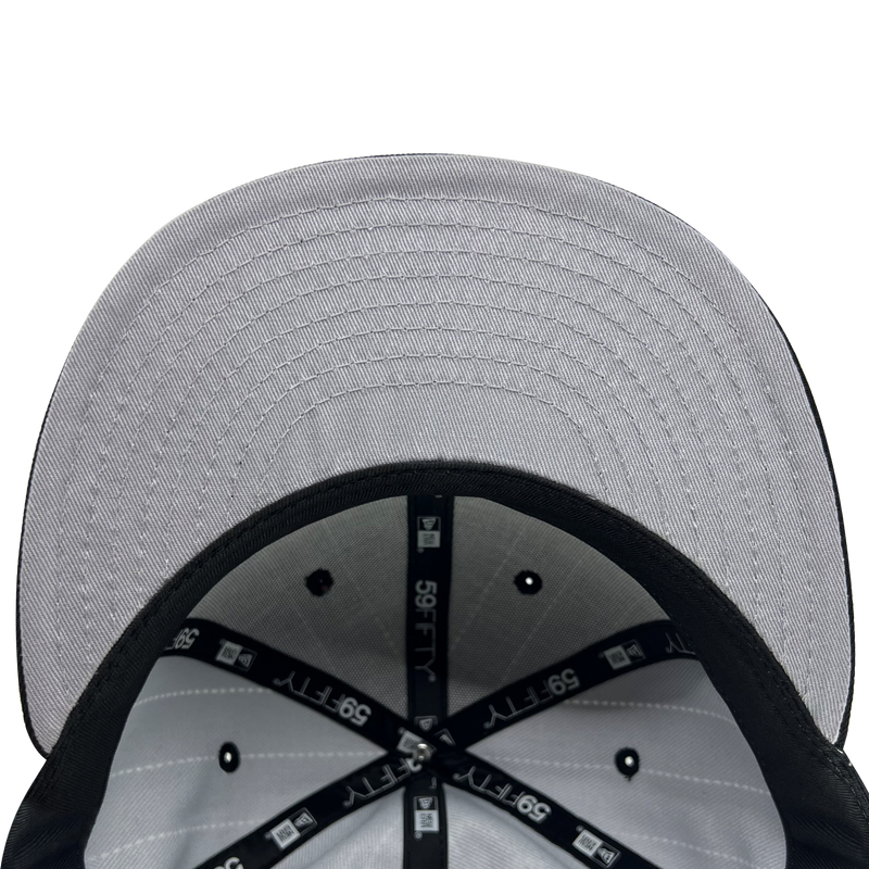 Inside the crown of New Era 9FIFTY fitted black pinstripe cap with black taping with New Era wordmark on repeat and grey under visor.