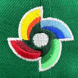 Detailed close-up of embroidered world baseball classic logo on the back of green fitted New Era cap.