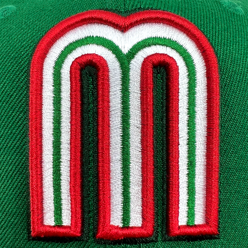 Detailed close-up of red and white Mexican baseball M patch on crown of New Era cap.