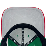 Gray undervisor and view inside crown of a green cap with black taping with black 9FORTY taping and New Era wordmarks on repeat.