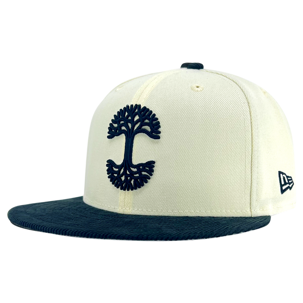 Fitted cap in chrome white, with a black corduroy brim and black embroidered Oaklandish tree logo - angled to show the New Era logo on left wear side.