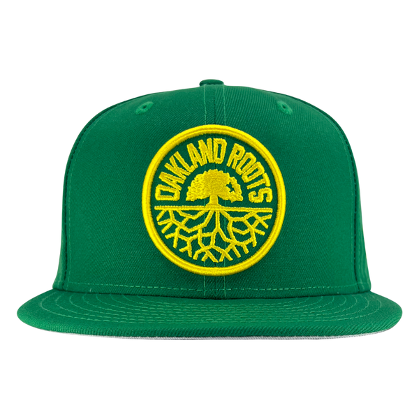 New Era 59FIFTY kelly green snapback hat with a yellow embroidered Oakland Roots SC crest.