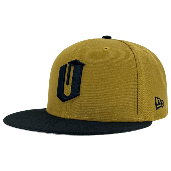 New Era 59FIFTY gold fitted cap with black embroidered O for Oakland & black bill. It is angled to show the New Era logo on the left wear side.