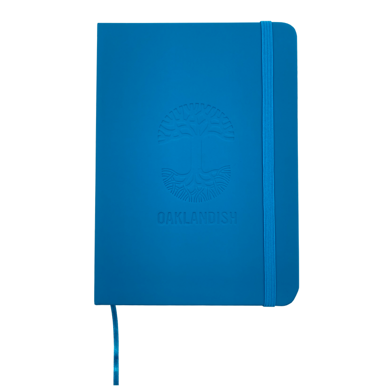 Top view of blue Oaklandish journal notebook elastic closure and bookmark with Oakalndish tree logo and wordmark embossed on the cover. 