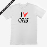 White t-shirt with ”I Oak” in black old-time font and a red map of Oakland replacing the heart between I and Oak.