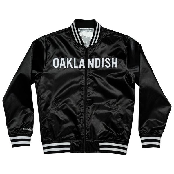 Mitchell & Ness black satin reversible jacket with Oaklandish wordmark across front chest with black and white ribbing at collar, cuff, and waistband.