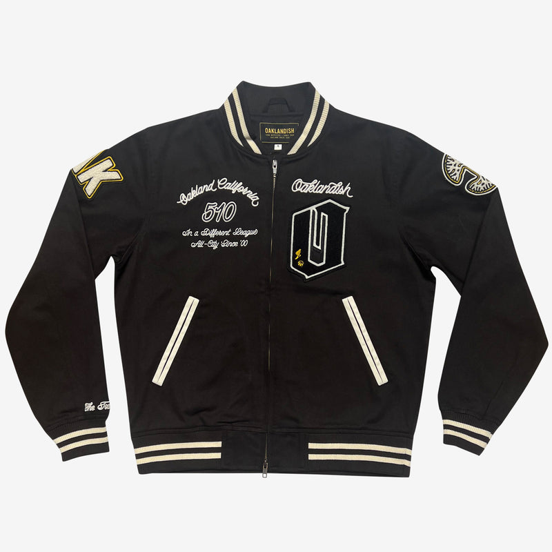 Black zip-up cadet jacket with Oaklandish chenille patches on sleeves and chest and black and white striped ribbing on the bottom, the cuffs & the neck.