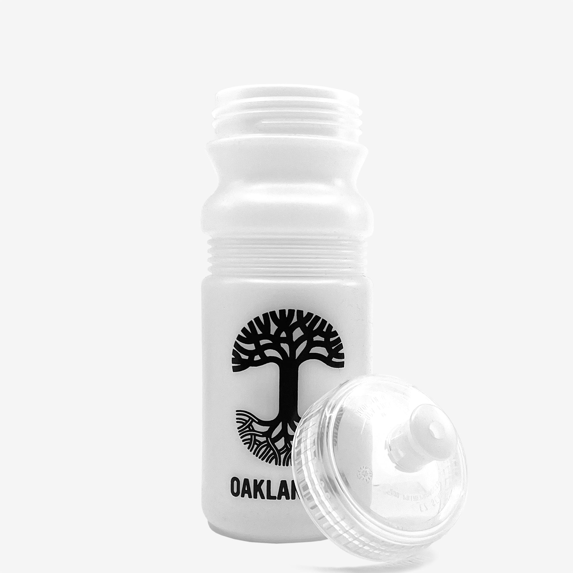 Unscrewed frost white bicycle water bottle with a black Oaklandish tree logo and wordmark .