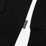 Close up of small Oaklandish wordmark tag on the side of a black hoodie.