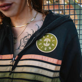 Close up of chest on a female model wearing black Oaklandish zip-up hoodie.