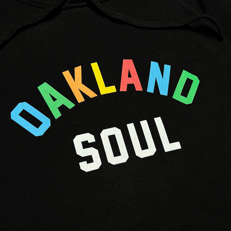 Close up of full-color OAKLAND wordmark and white SOUL wordmark underneath it on the chest of black hoodie.