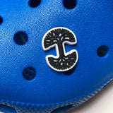 Shoe or clog charm of Oaklandish tree logo in black and white on a blue clog.