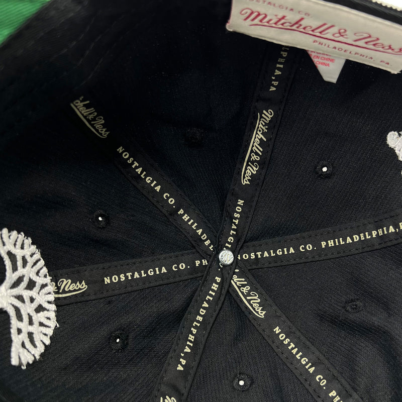 Detailed close-up of Mitchell & Ness taping inside the crown of a black dad cap.