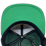 Detailed close-up of green undervisor and taping inside the crown of an Oaklandish x Mitchell & Ness cap.