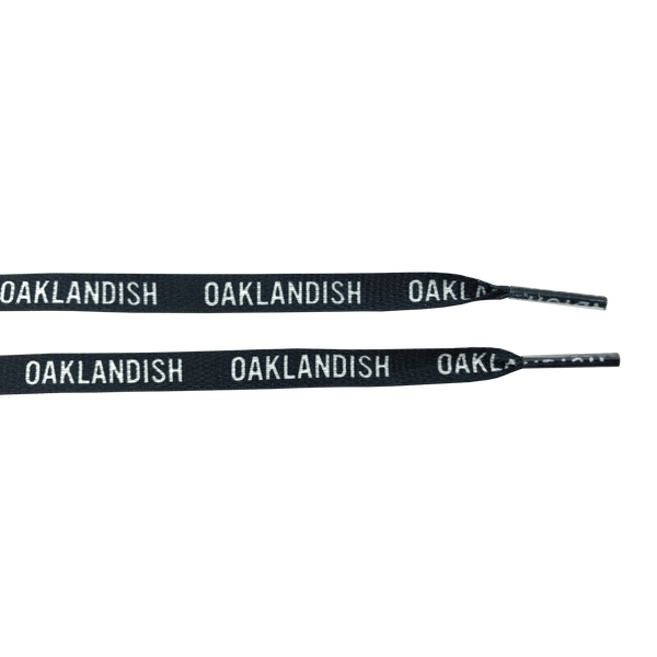 Ends of two black shoelaces with white OAKLANDISH wordmark on repeat.