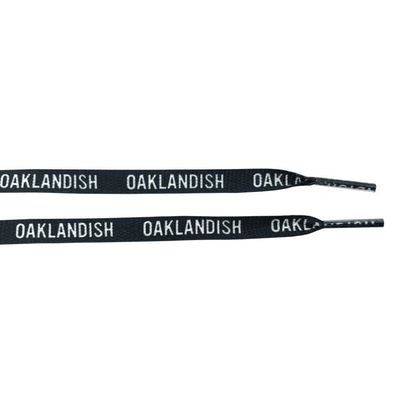 Ends of two black shoelaces with white OAKLANDISH wordmark on repeat.