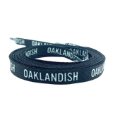 Two rolled up black shoelaces with white OAKLANDISH wordmark on repeat.
