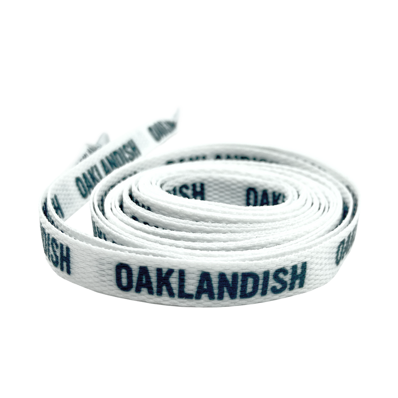 Rolled white shoelace with black Oaklandish wordmark on repeat.