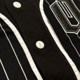 Close-up of white button closures on a black baseball jersey with white stripes.