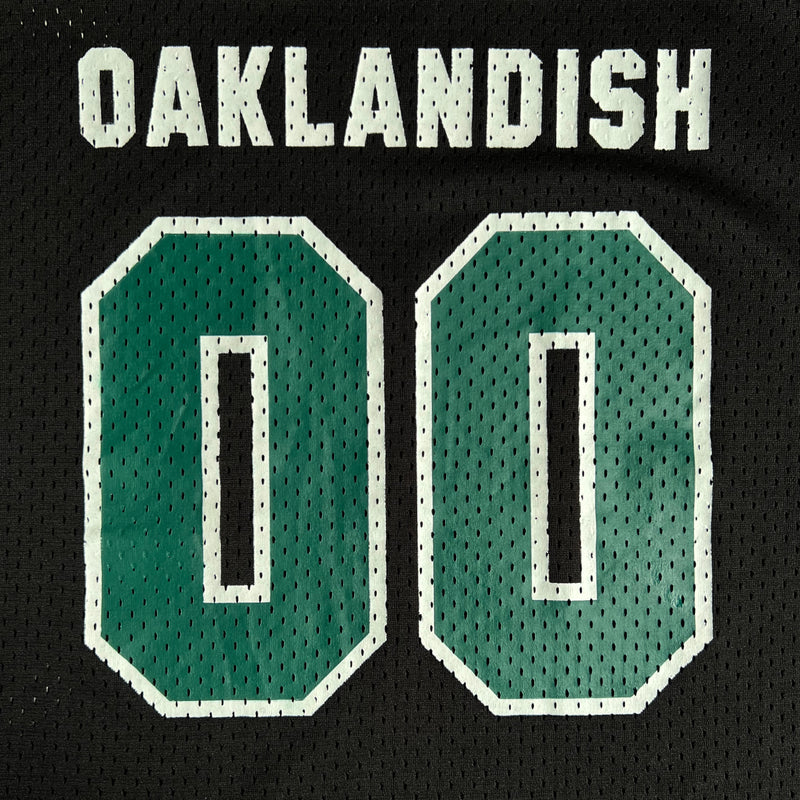 Close-up of 00 green numbers outlined in white and large white Oaklandish wordmark on black mesh football jersey.