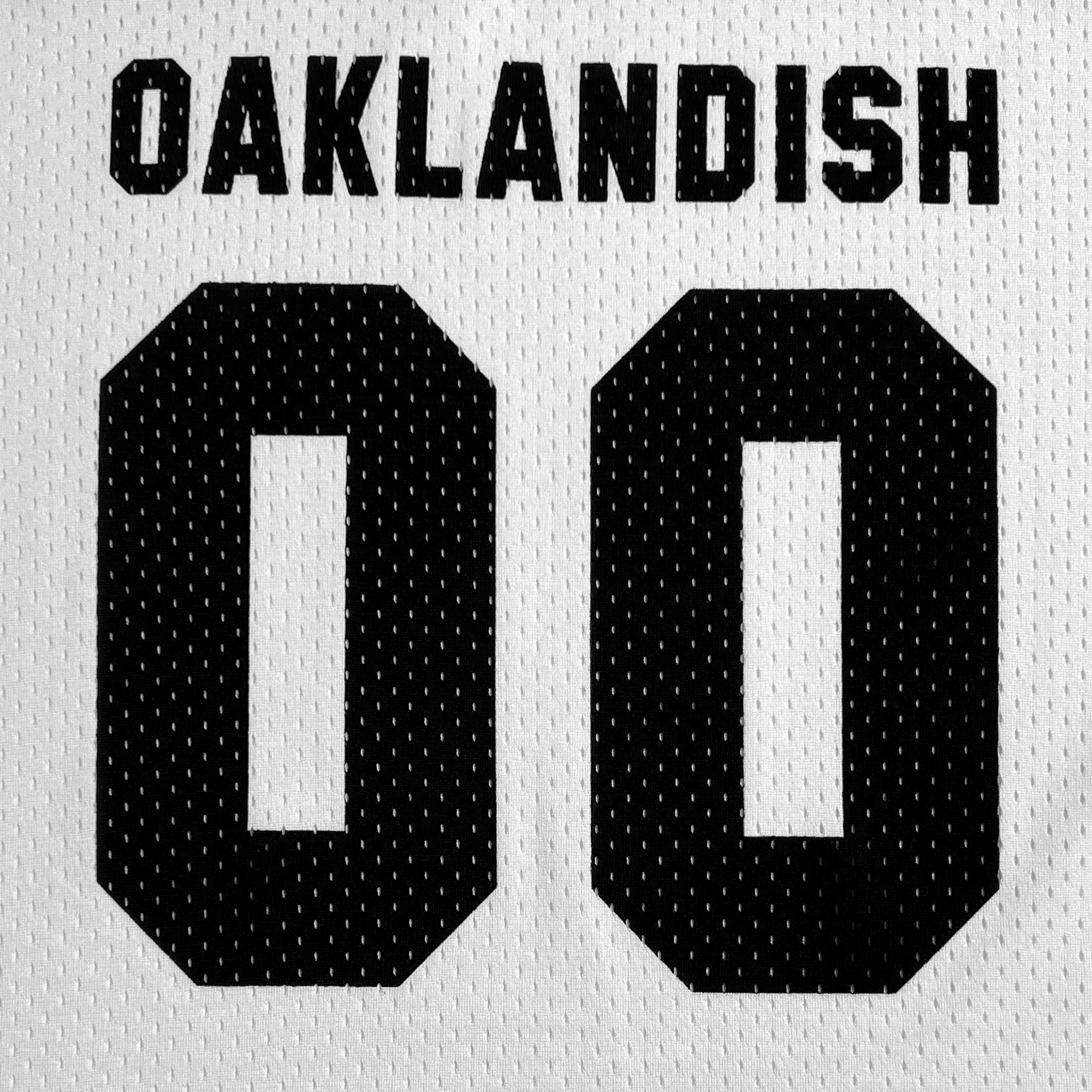 The Official Football Away Jersey by Other is a lightweight white mesh jersey with a black perforated texture, featuring bold black letters and numbers. It reads "OAKLANDISH" at the top with the number "00" prominently displayed below.
