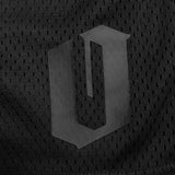 Close up of Official O for Oakland  logo on the bottom of left leg of men’s black mesh athletic shorts. 