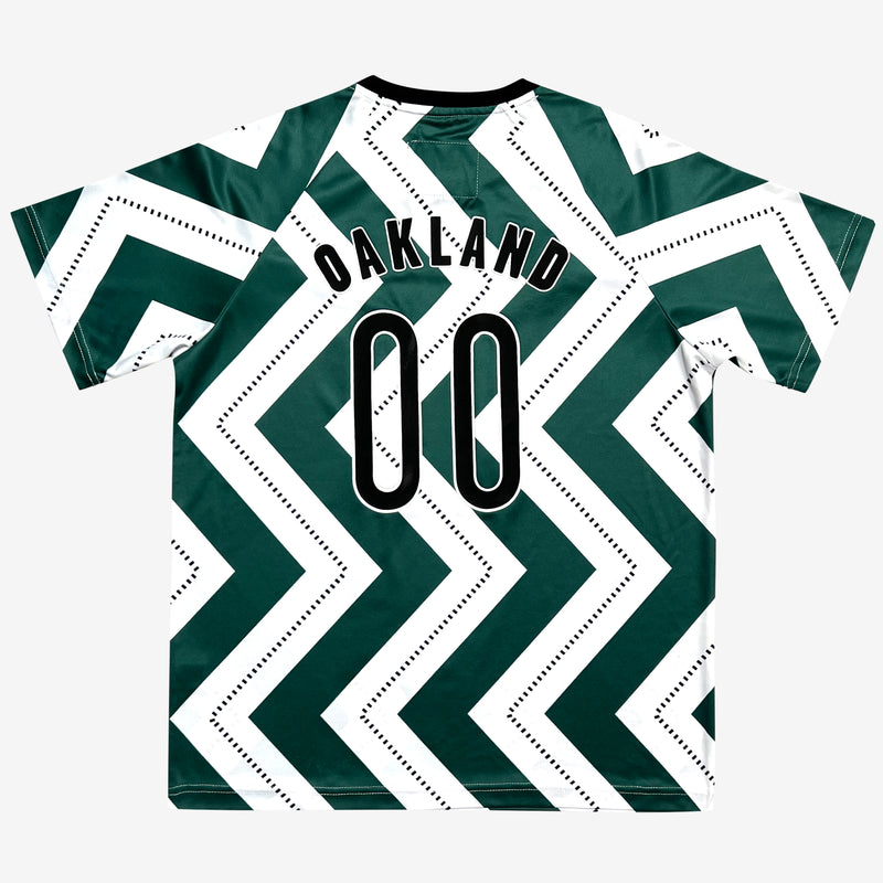 The back side of a soccer jersey with a green and white zig-zag pattern and OAKLAND 00 wordmark.