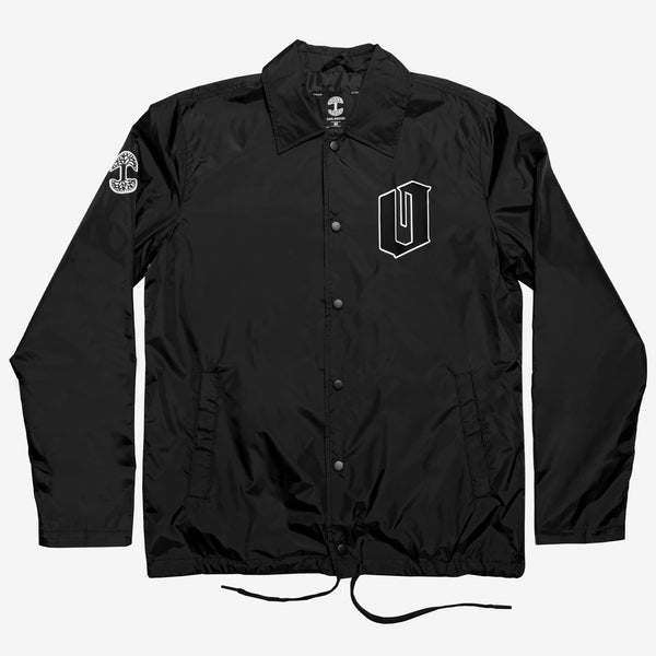 Black nylon coaches jacket, button up closure, black & white Oaklandish O logo on left chest and tree logo on right sleeve.