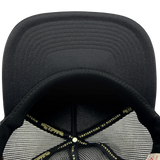 Detailed close-up of black undervisor and taping inside the crown of a black Mitchell & Ness truckers cap.