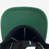 Contrasting forest green under brim angle and inside of black snapback hat crown with ‘OAKLANDISH’ wordmark on black striping