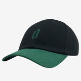 Side view of black dad hat with forest embroidered 'O' logo on crown and contrasting forest  green brim.