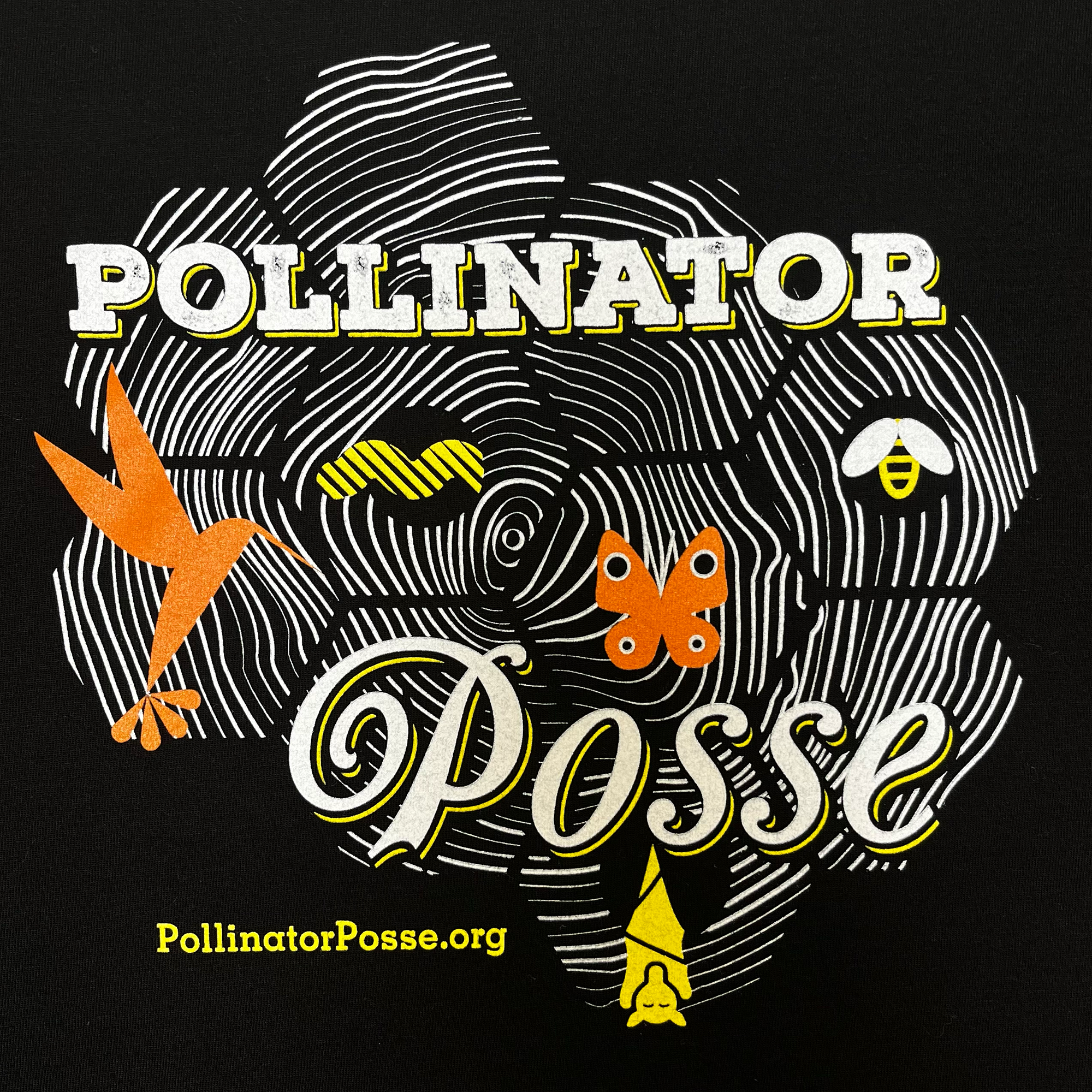 Close-up on Pollinator Posse graphic on the front chest of a black t-shirt.