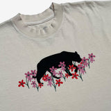 Close-up of creme t-shirt with artistic bear and flower design created by artist Ant Bankxin.