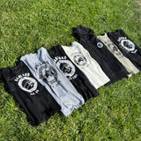 Group photo of Black Panther Party Alumni Legacy Network t-shirt collection outside on grass.