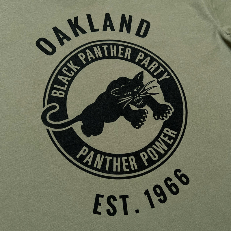 Detailed close up image of men's eucalyptus t-shirt with Black Panther Party Alumni Legacy Network logo.