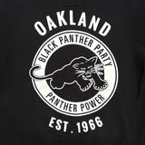 Detailed close-up of large white Black Panther Party Alumni Legacy Network logo on the back of a black hoodie.