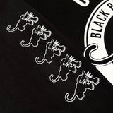Detailed close of the panther in the Black Panther logo on repeat on the right sleeve of a black t-shirt.