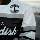 Close-up of the black Oaklandish tree logo on the chest of a striped satin jacket.
